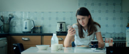 Girl with iPhone at breakfast table