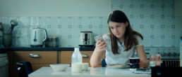 Girl with iPhone at breakfast table
